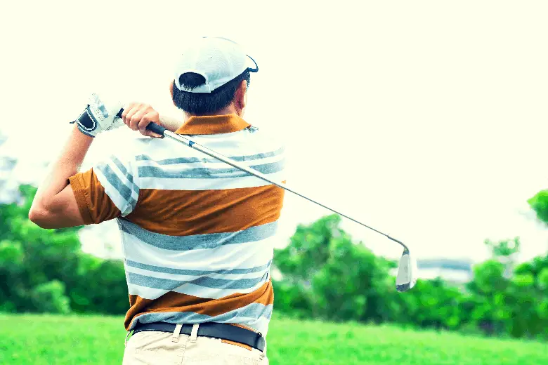 Golfer finishing golf swing using baseball grip