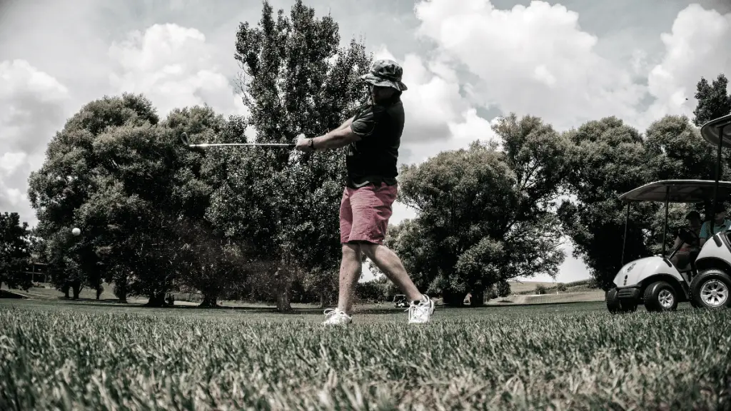 Man Swinging Golf Club wearing Bucket Hat