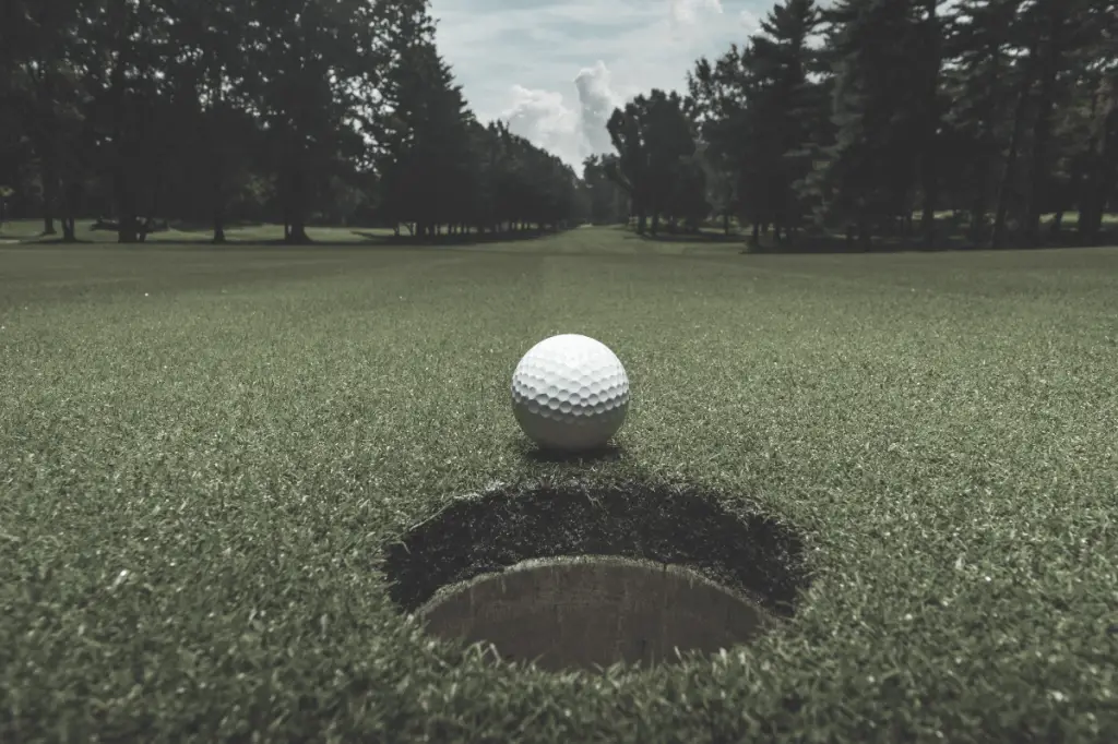 golf ball going into cup