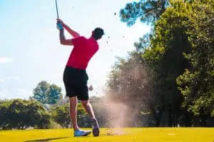golfer hitting wedge shot on golf course