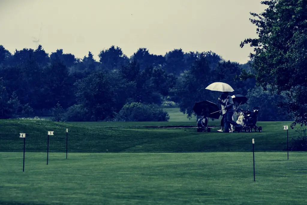 Golfer holding golf umbrella