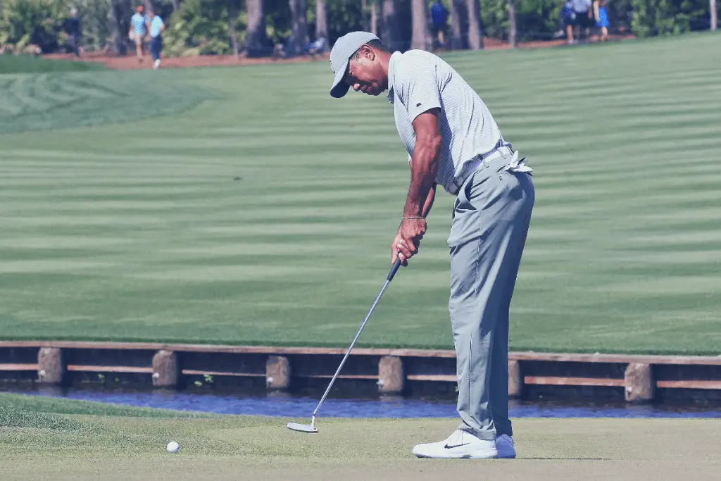 Tiger Woods using putter on green
