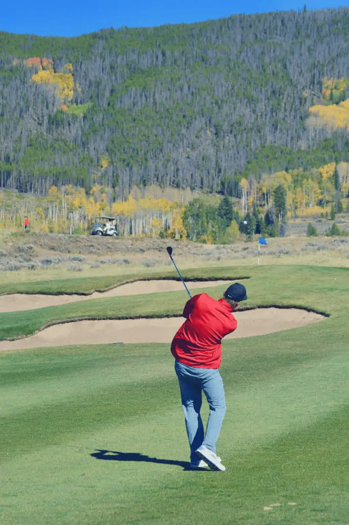 Golfer hitting 56 degree wedge onto the green