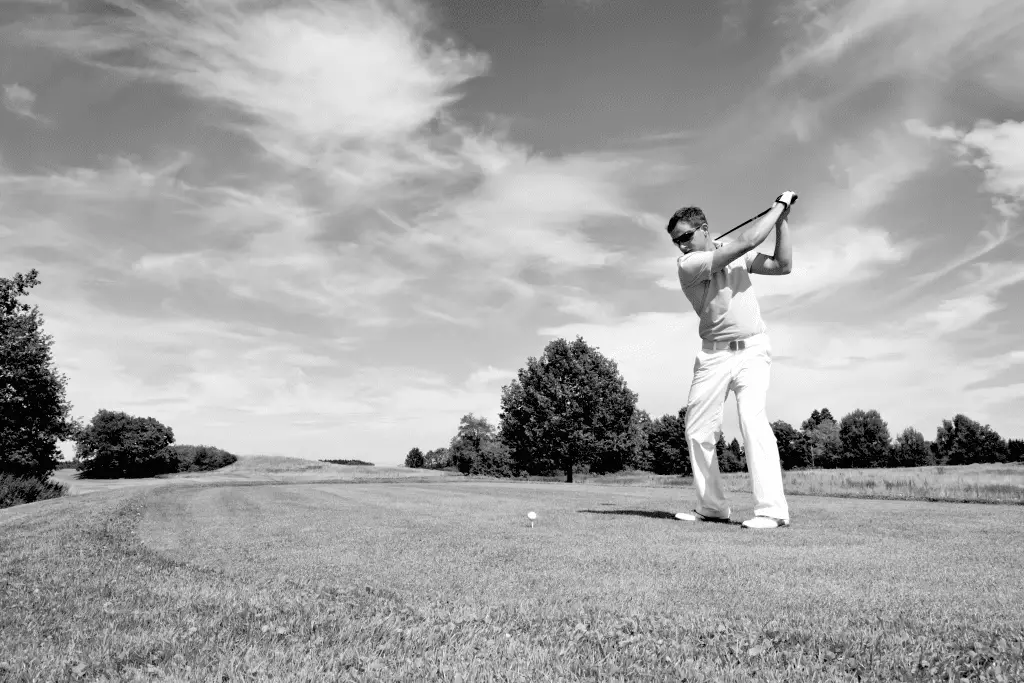 golfer hitting golf ball with driver