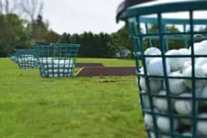 Buckets of Range Balls next to driving range hitting areas
